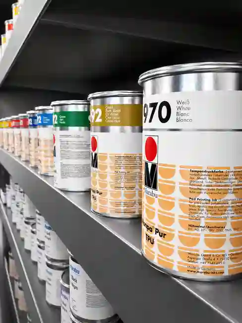 Close-up of Marabu TPU ink cans on a shelf, highlighting Marabu Class VI medical pad printing ink suitable for medical device printing.