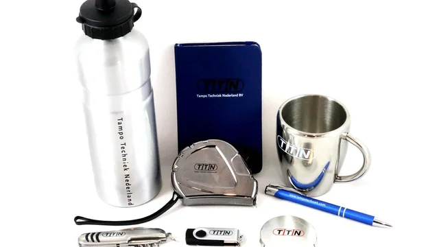 Collection of TTN branded promotional products including a water bottle, notebook, tape measure, mug, pen, multi-tool, and USB drive, showcasing versatile pad printing and industrial marking solutions by Automark